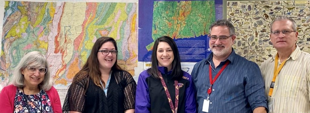 Prince Tech science department staff standing in front of a wall of maps.