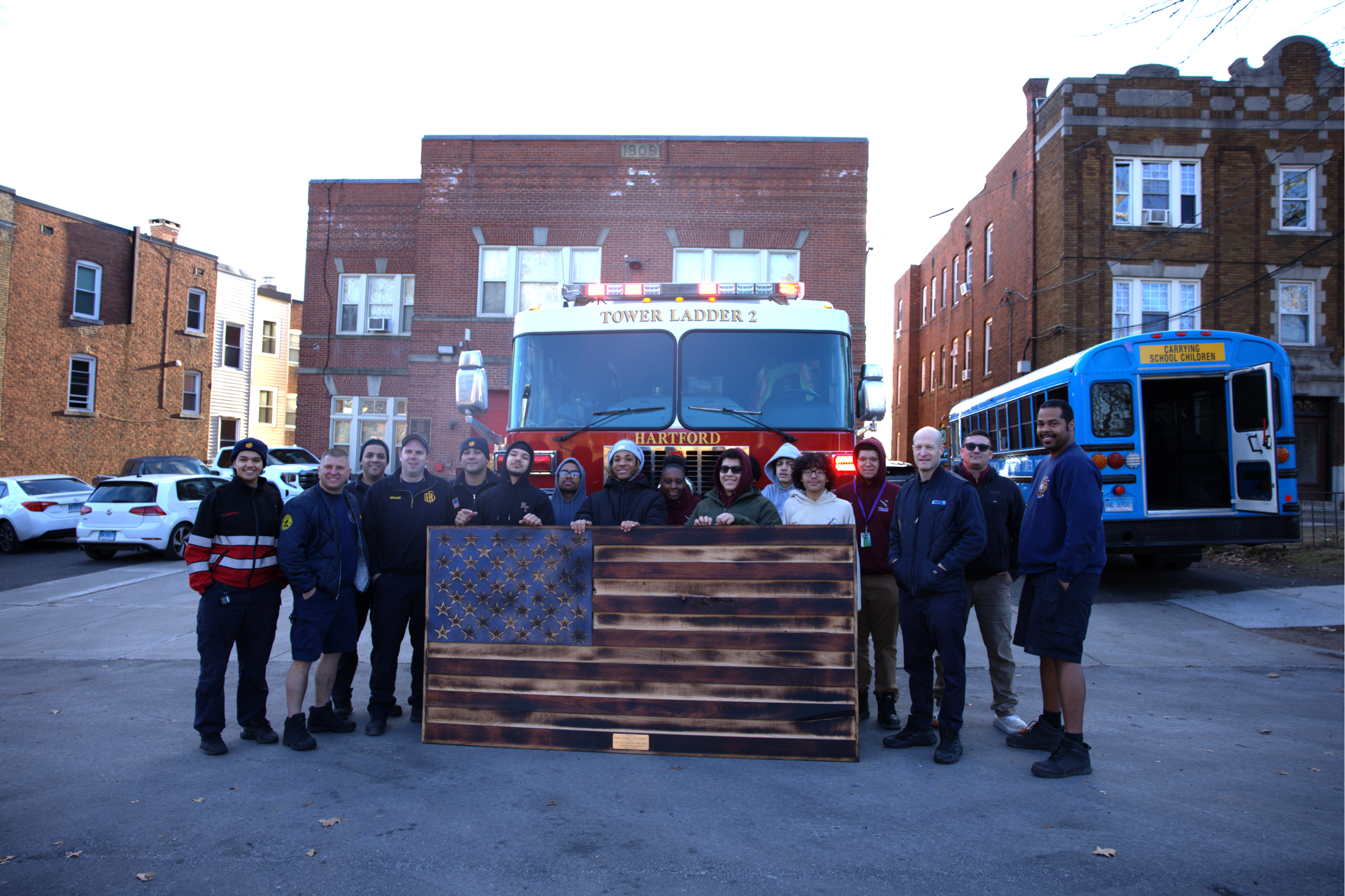 Photos of Carpentry students presenting the large wooden American flag to the firefighters and touring the facility.